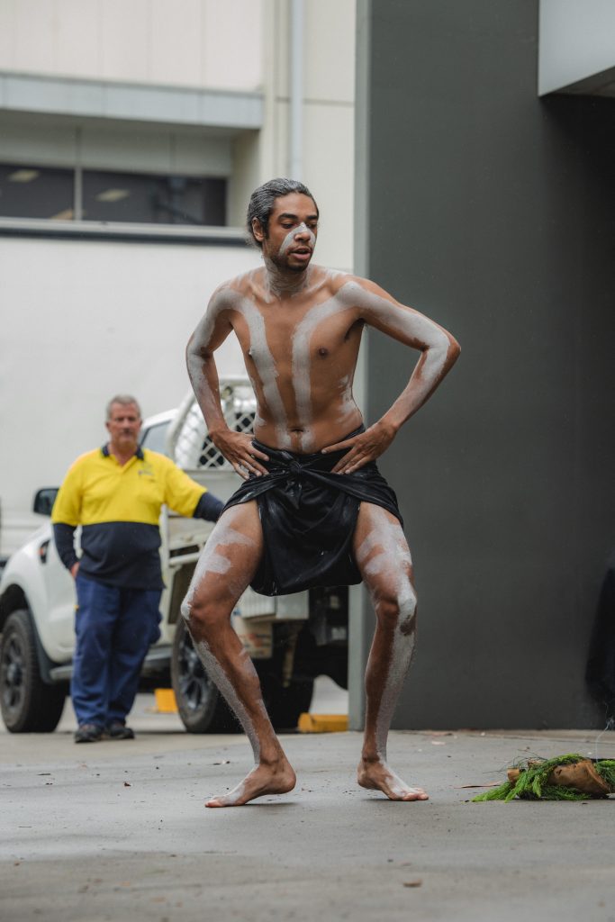 Aboriginal man performing a traditional dance with white body paint at a cultural ceremony for an Aboriginal-led organization